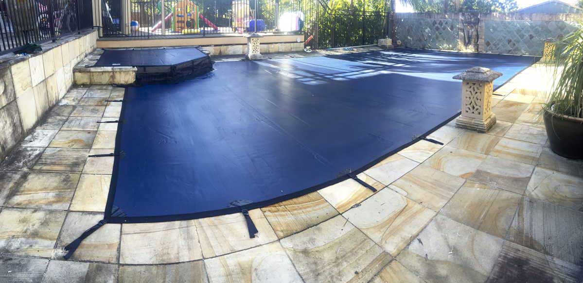 Custom-fitted cover for pool with raised spas in Central Coast, securely enveloping the entire pool area for enhanced safety and cleanliness.